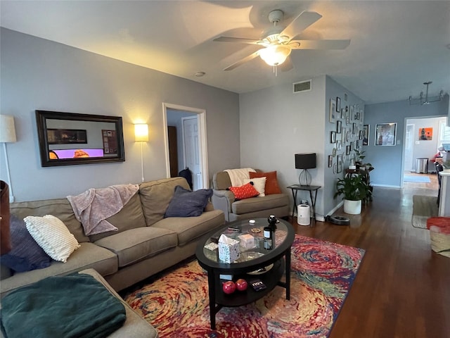 living room featuring ceiling fan and dark wood-type flooring