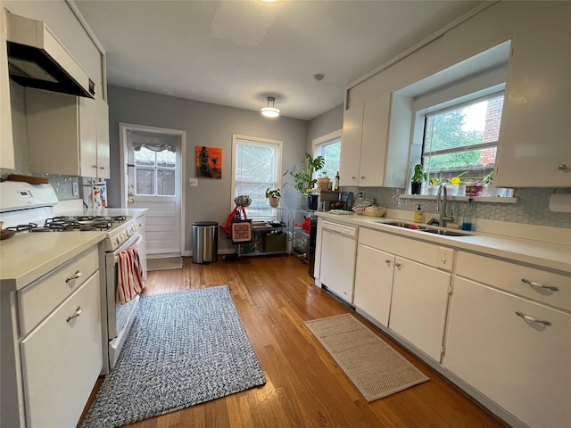 kitchen featuring white appliances, white cabinets, sink, tasteful backsplash, and light hardwood / wood-style floors