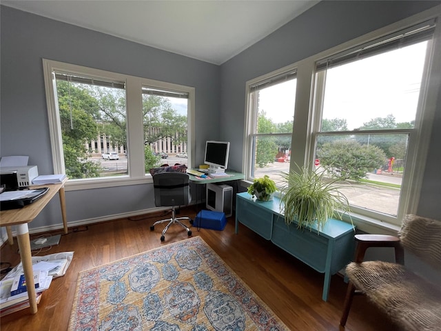 home office with dark hardwood / wood-style flooring and a healthy amount of sunlight