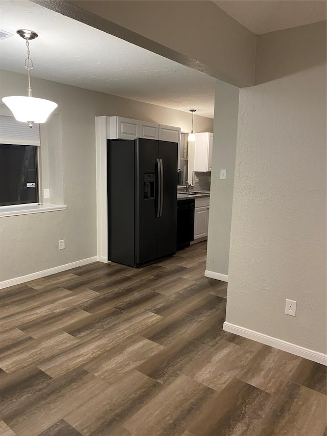 kitchen featuring white cabinetry, dark wood-type flooring, hanging light fixtures, and black appliances