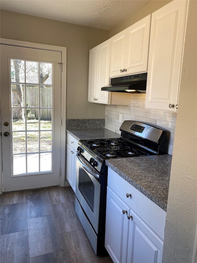 kitchen with a textured ceiling, gas stove, decorative backsplash, and white cabinets