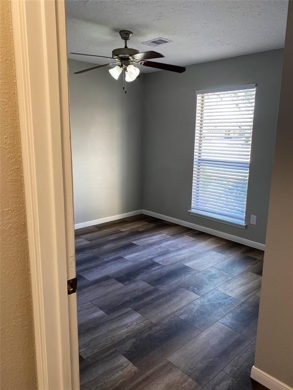 empty room with ceiling fan and a textured ceiling