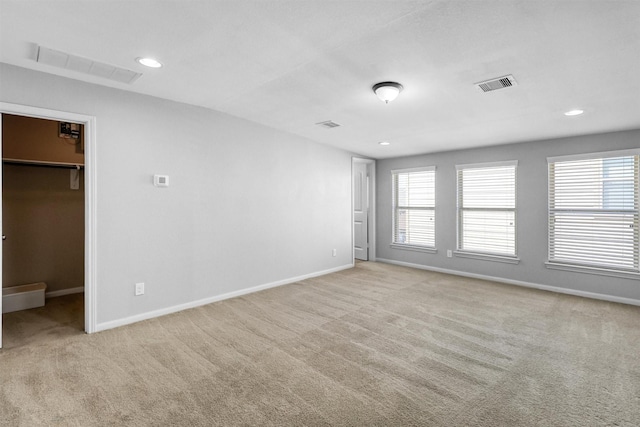 unfurnished room featuring light carpet and plenty of natural light