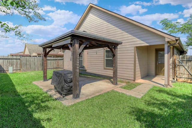 back of property with a lawn, a patio area, and a gazebo