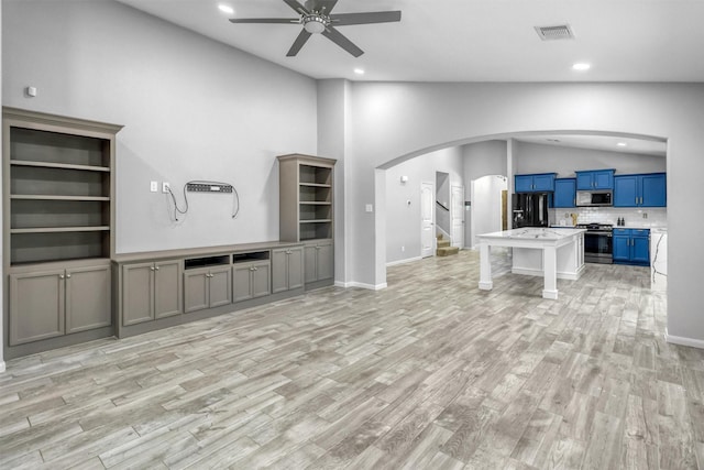 unfurnished living room featuring light hardwood / wood-style floors, high vaulted ceiling, and ceiling fan