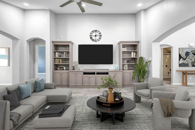 living room with a high ceiling and ceiling fan