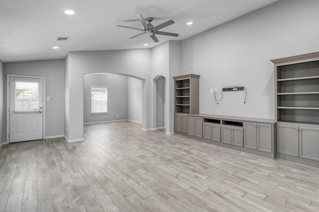 unfurnished living room featuring ceiling fan, vaulted ceiling, and light wood-type flooring