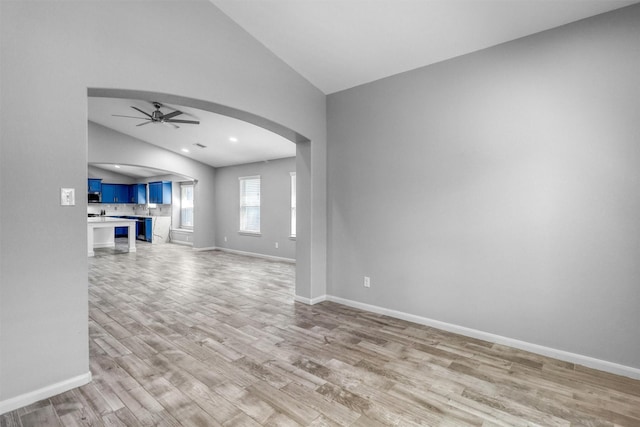 unfurnished living room with light hardwood / wood-style floors, ceiling fan, and lofted ceiling