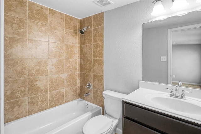 full bathroom with vanity, tiled shower / bath combo, and toilet