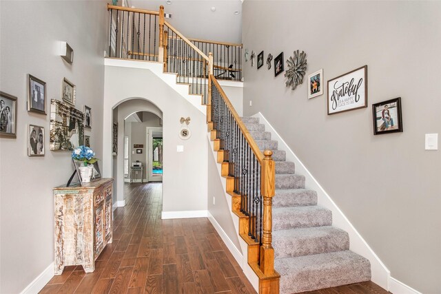 staircase featuring a towering ceiling