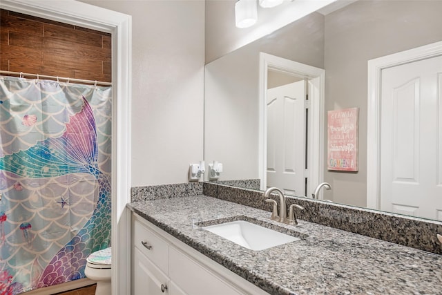 bathroom featuring curtained shower, vanity, and toilet