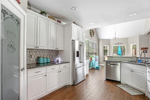 kitchen featuring appliances with stainless steel finishes, tasteful backsplash, white cabinetry, and sink