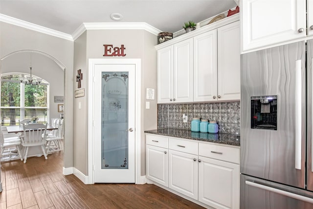 kitchen featuring dark wood-type flooring, tasteful backsplash, a notable chandelier, stainless steel fridge, and white cabinets