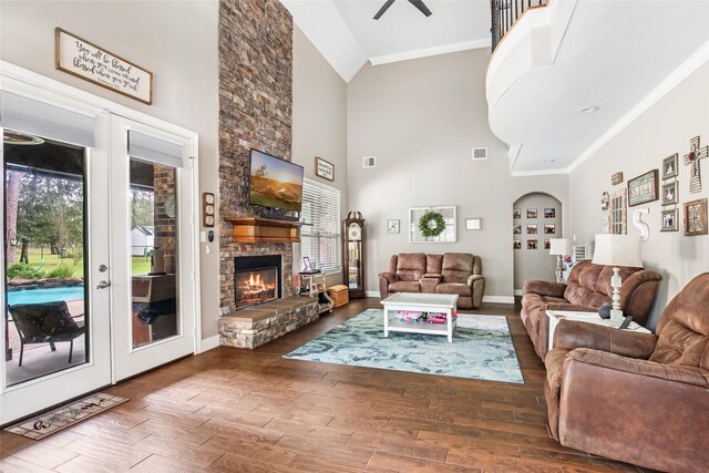 living room with a fireplace, high vaulted ceiling, ceiling fan, and ornamental molding