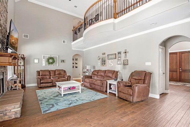 living room with dark hardwood / wood-style floors, ornamental molding, and a high ceiling