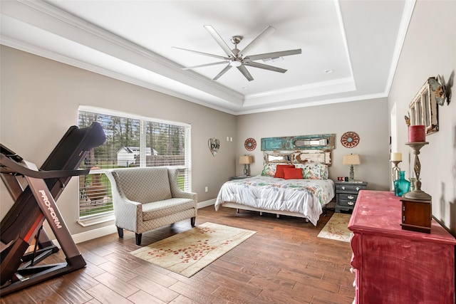 bedroom featuring ceiling fan, dark hardwood / wood-style floors, a raised ceiling, and ornamental molding