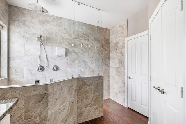 bathroom with hardwood / wood-style floors, vanity, and tiled shower