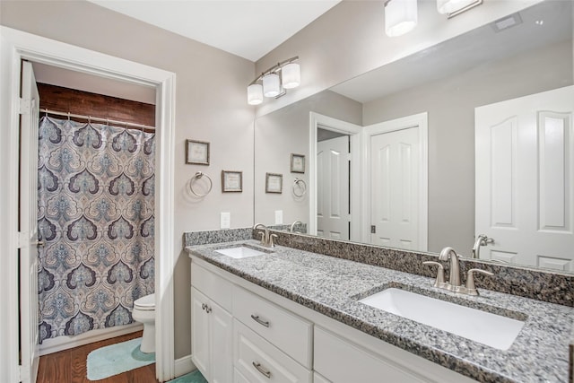 bathroom with a shower with curtain, vanity, hardwood / wood-style flooring, and toilet