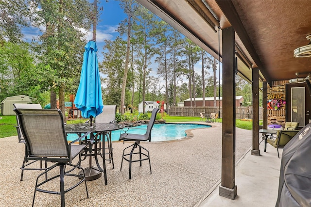 view of swimming pool with a shed and a patio