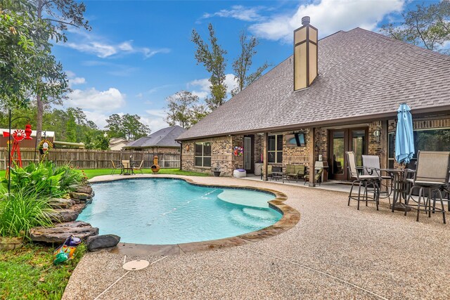 view of swimming pool with a patio area and french doors