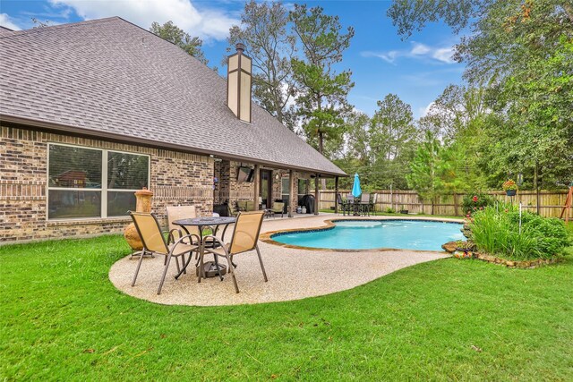 view of pool with a lawn and a patio area