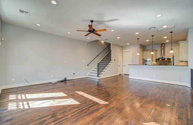 unfurnished living room featuring ceiling fan and dark hardwood / wood-style flooring