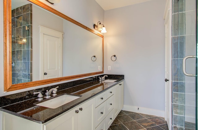 bathroom featuring a shower with door and vanity