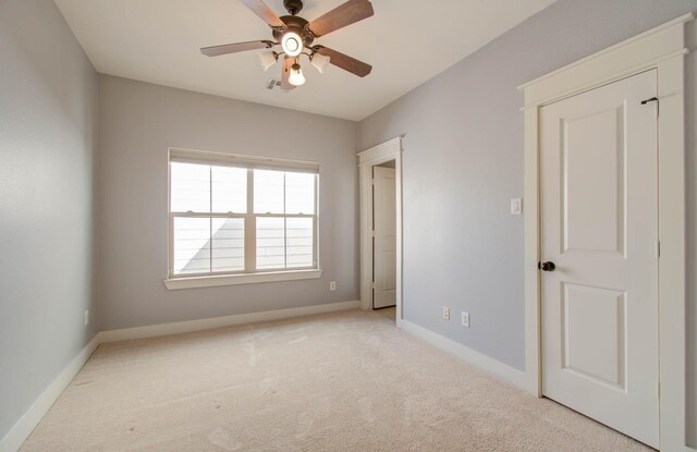 carpeted spare room with ceiling fan