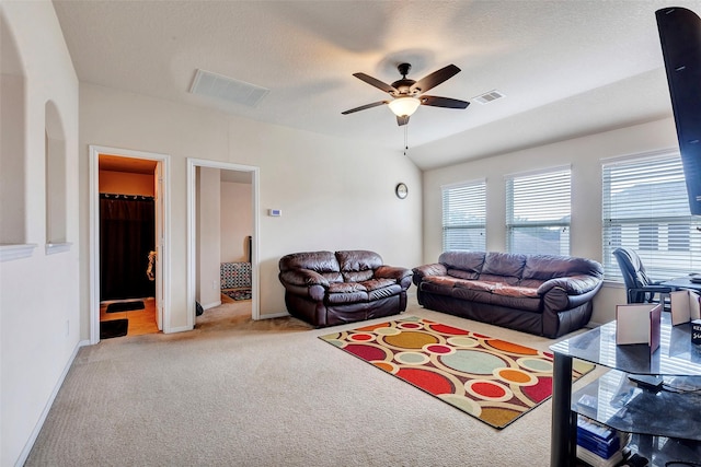 living room featuring light carpet, a textured ceiling, ceiling fan, and lofted ceiling