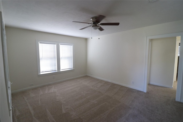 carpeted spare room with ceiling fan