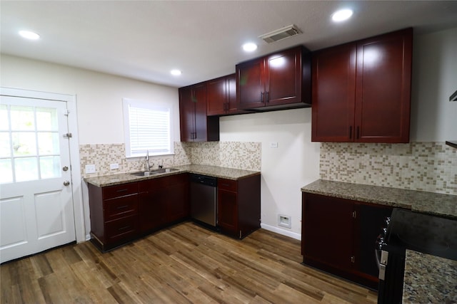 kitchen with stone counters, dishwasher, sink, dark hardwood / wood-style floors, and plenty of natural light