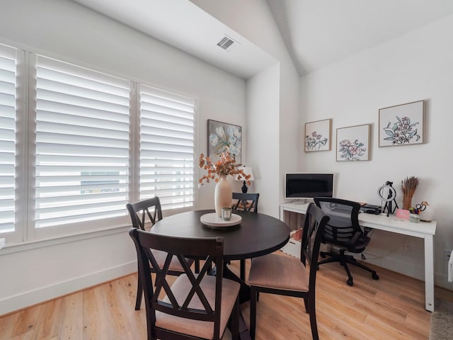 dining space with light hardwood / wood-style flooring and lofted ceiling