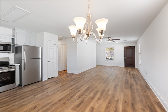 kitchen with pendant lighting, white cabinets, ceiling fan with notable chandelier, wood-type flooring, and stainless steel appliances