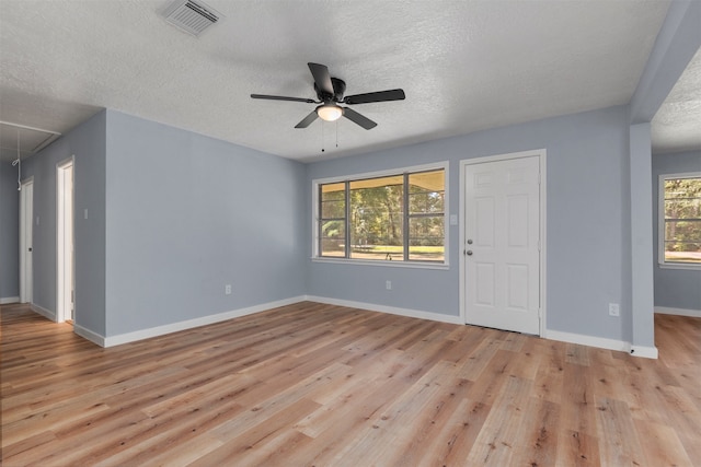 interior space with ceiling fan, plenty of natural light, a textured ceiling, and light hardwood / wood-style flooring