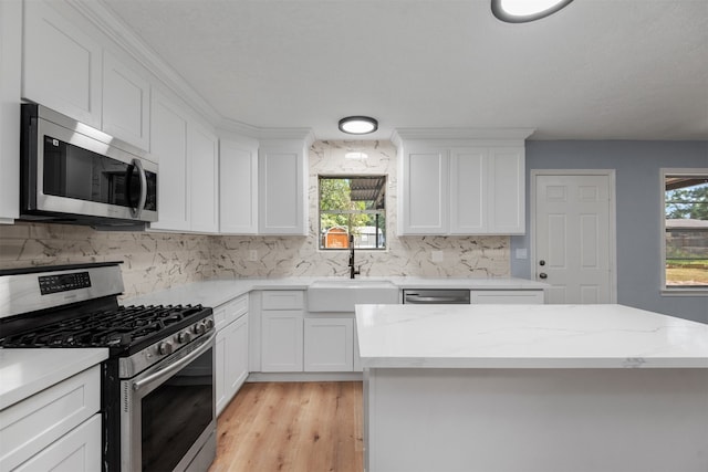 kitchen featuring a healthy amount of sunlight, sink, white cabinets, and stainless steel appliances