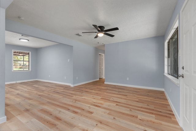 empty room featuring a textured ceiling, light hardwood / wood-style flooring, and ceiling fan