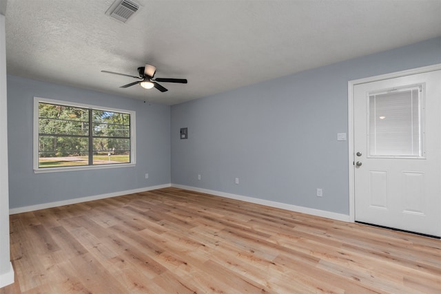 unfurnished room featuring a textured ceiling, light hardwood / wood-style flooring, and ceiling fan