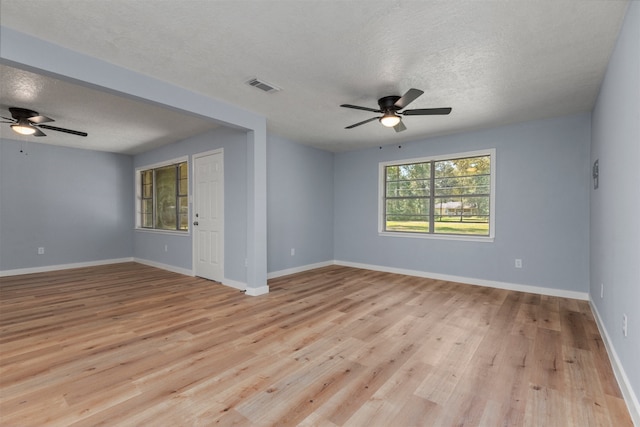 unfurnished room featuring ceiling fan, light hardwood / wood-style flooring, and a textured ceiling