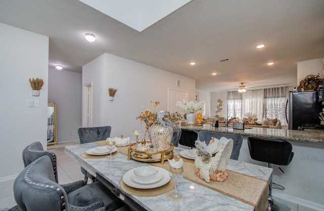 tiled dining room featuring ceiling fan