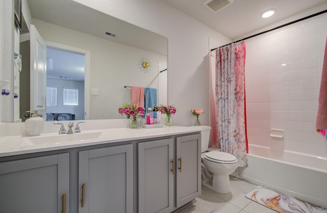 full bathroom featuring tile patterned floors, shower / tub combo with curtain, vanity, and toilet