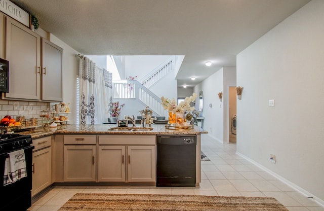 kitchen with light stone countertops, tasteful backsplash, sink, black appliances, and light tile patterned floors