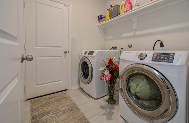 laundry room with washer and clothes dryer and light tile patterned floors