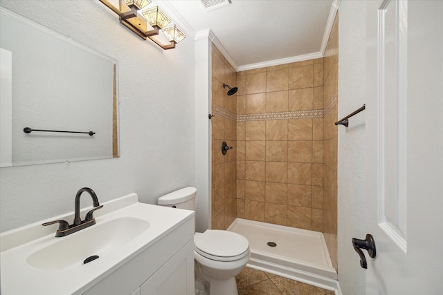 bathroom with vanity, crown molding, tile patterned flooring, toilet, and a tile shower