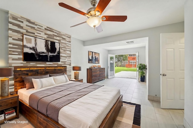 bedroom featuring access to exterior, light tile patterned floors, and ceiling fan