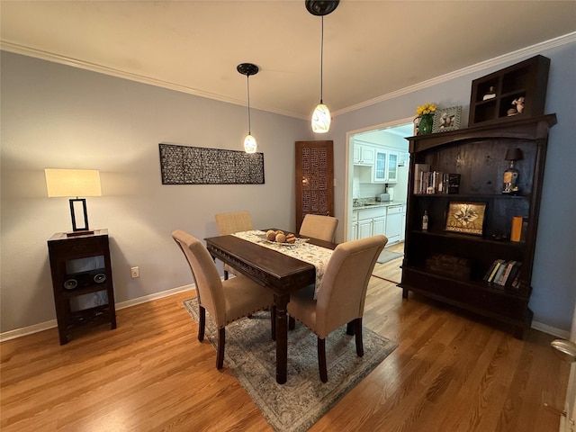 dining area featuring hardwood / wood-style floors and ornamental molding