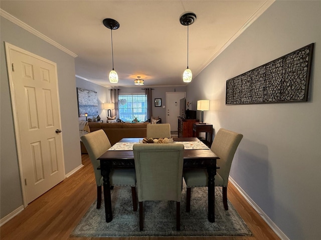 dining space with dark hardwood / wood-style floors and ornamental molding