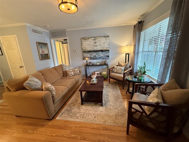 living room with a wealth of natural light, light wood-type flooring, and ornamental molding