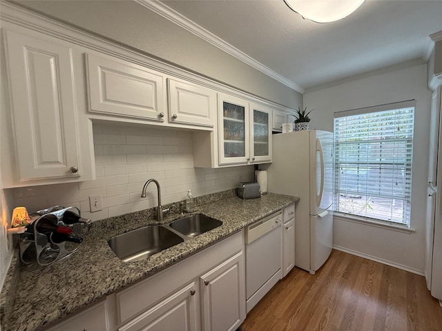 kitchen with light stone counters, white appliances, sink, hardwood / wood-style flooring, and white cabinetry