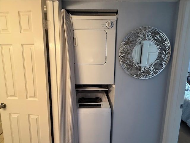 laundry room featuring stacked washer / drying machine