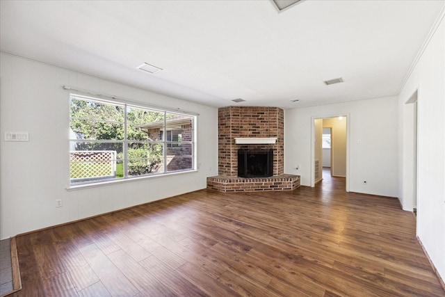 unfurnished living room with dark hardwood / wood-style flooring and a brick fireplace